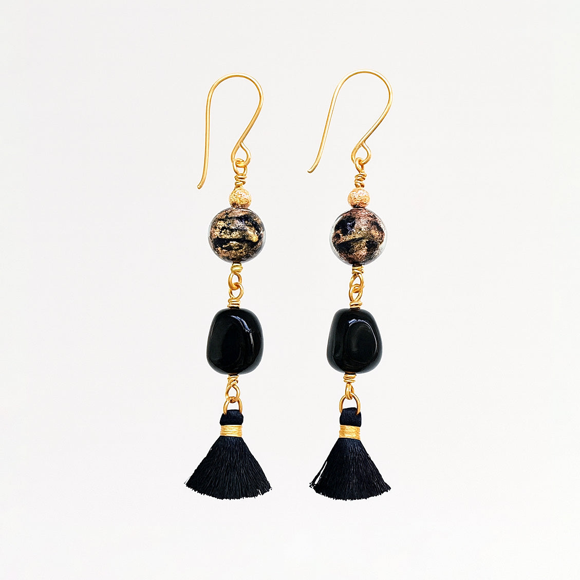 Mustakultaiset korvakorut tupsulla